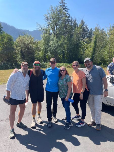 A group standing together with mountains behind them