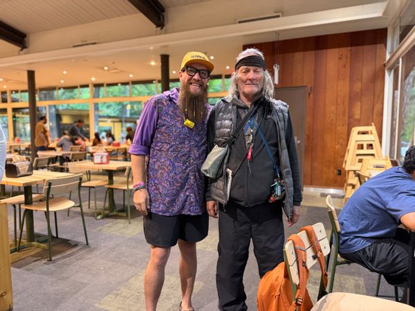 Two hikers standing together indoors