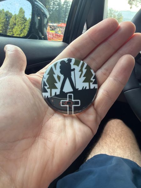 An In The Hedges ministry sticker held in a hand